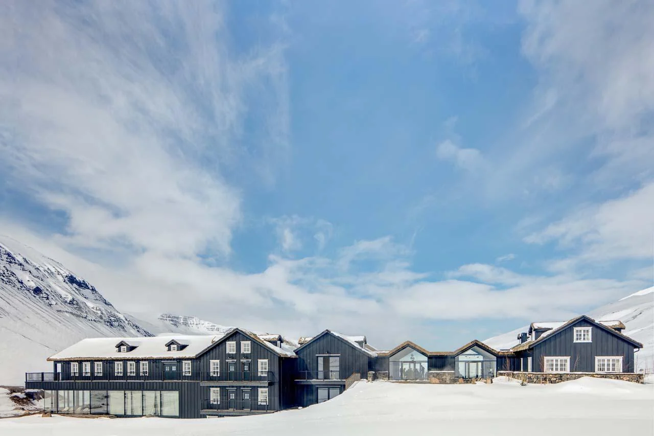 雪山前排列的深色建筑