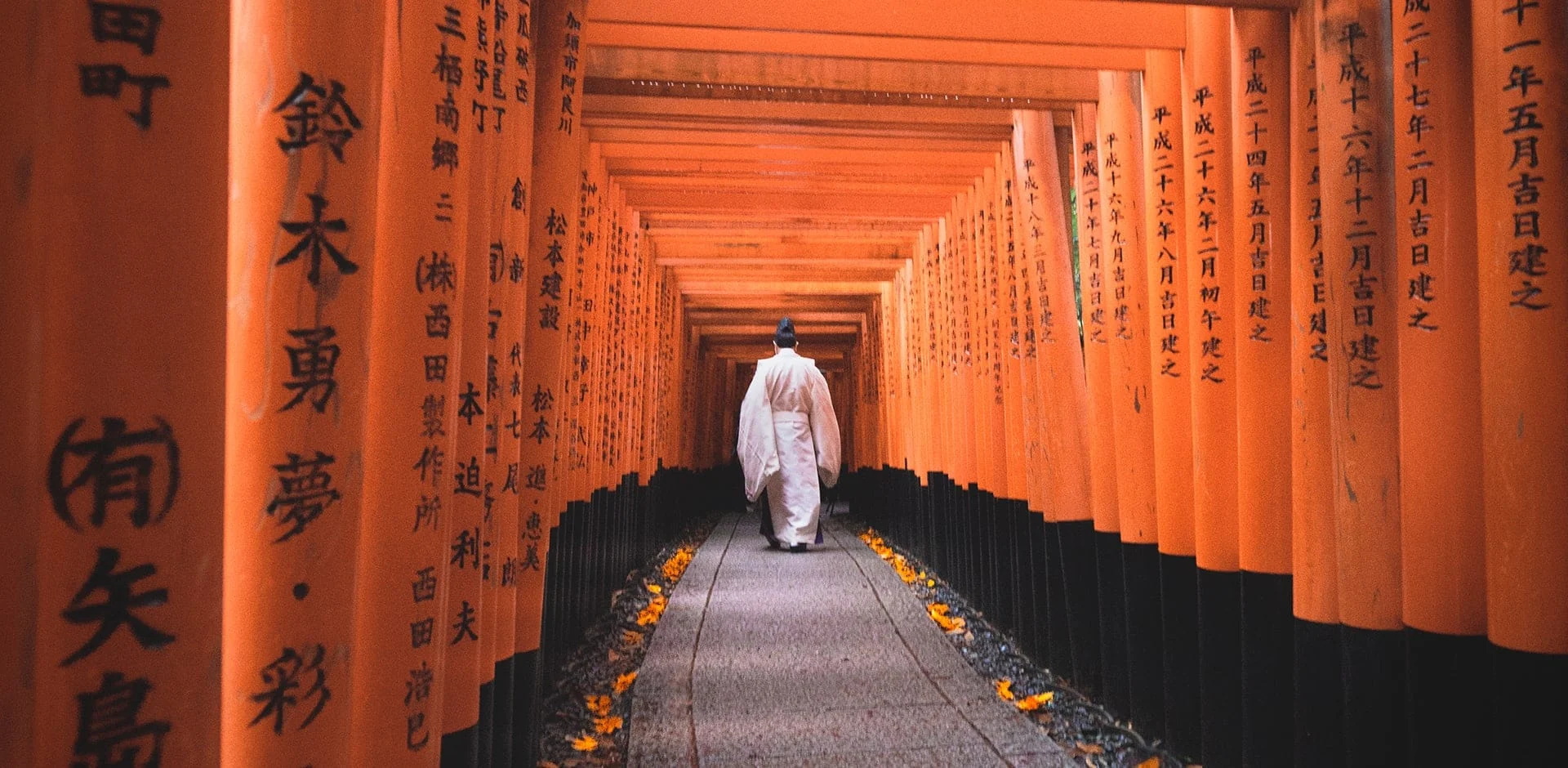 身着白衣的旅客走过朱红鸟居